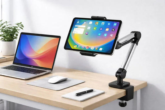 A desk mounted tablet stand beside a laptop.