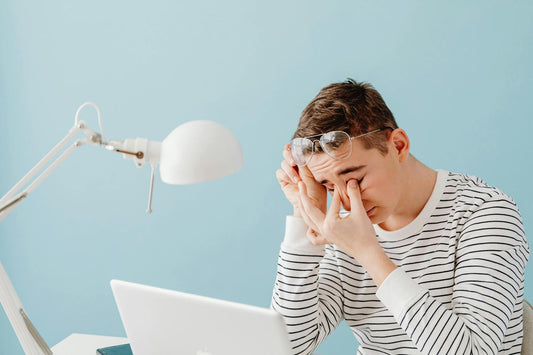 A man with eye strain from laptop use